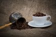 Cezve and cup with freshly roasted coffee beans on sackcloth