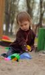 Little beauty girl playing at sand-box