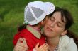 little girl with her mother in the spring park kissing