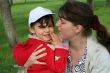 little girl with her mother in the spring park kissing