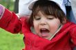 little girl is crying outdoors in spring park