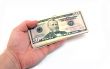 The hand stretching a pack of dollars