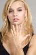 a blonde woman looks through her finger