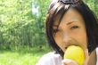 young happy woman eating apple