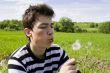 Teenager blowing dandelion