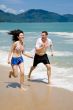 couple racing on the beach with joy