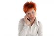 red haired woman talking by mobile phone unhappy