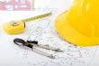 Building plan with safety helmet, pair of compasses and rolling