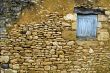 Old yellow stone wall with close window