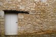 Old yellow stone wall with white door