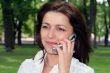 young woman is talking by mobile phone in a park