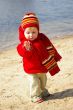 Girl plays with sand on coast of lake