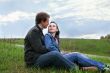 Guy and beautiful girl sits on a grass