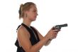 young blond woman in black dress with revolver isolated on white background