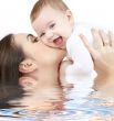 laughing baby playing with mother in water