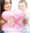 baby and mama with heart-shaped pillow