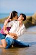 loving young couple kissing while squating by the beach