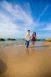 happy young couple running on the beach