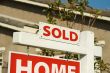 Sold Home For Sale Sign & New House