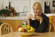 Woman with Cup of Coffee in Kitchen Smiling