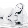 Studio portrait of a young blond woman lying by the water
