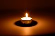 Burning candle in darkness