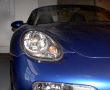 Headlight of the dark blue sports automobile.