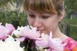 Beautiful young woman holding pink peony