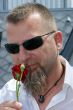 Young man with a red rose and sunglasses.
