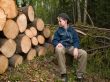 boy sitting near the prepared logs