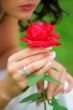 Woman holding single red rose