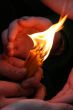 Flaming candle upon palms protection