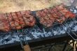 Preparing meat barbecue upon open fire