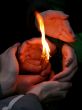Flaming candle upon palms protection