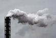 Smoking industrial pipe on gray sky