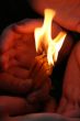 Flaming candle upon palms protection