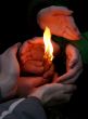 Flaming candle upon palms protection