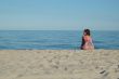 Young woman is sitting on the beach 2