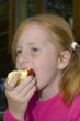 little girl is eating an apple