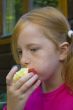 little girl is eating an apple