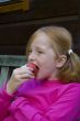 little girl is eating an apple
