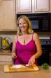 Blond woman cutting food in kitchen