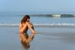 Beautiful girl sitting on the ocean beach