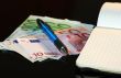 Money, notebook and pencil