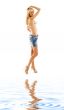 blond in denim skirt and bikini on white sand