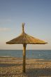 Single thatched umbrella on beach