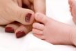 Mother`s hand and baby`s foot