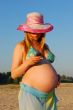 The river, beach, the pregnant girl speaks by phone.