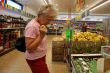 Old woman buys salad in a supermarket