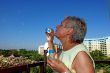 Old woman makes soap bubbles.
